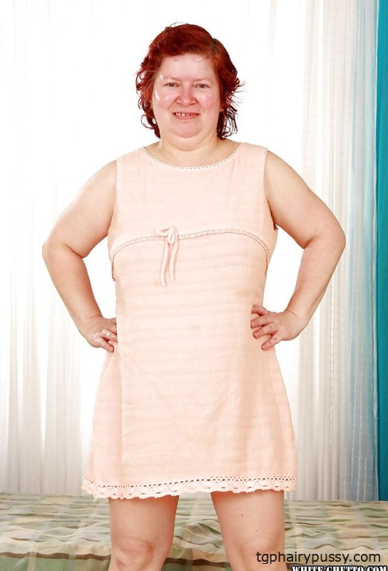 Толстая рыжая бабушка с массивными кувшинами снимает с себя одежду