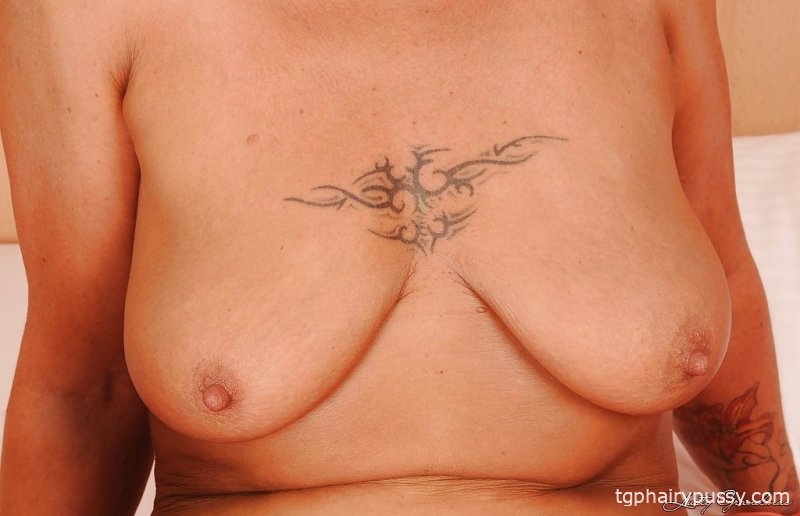 Бабушка-блондинка с большой грудью снимает нижнее белье на кровати