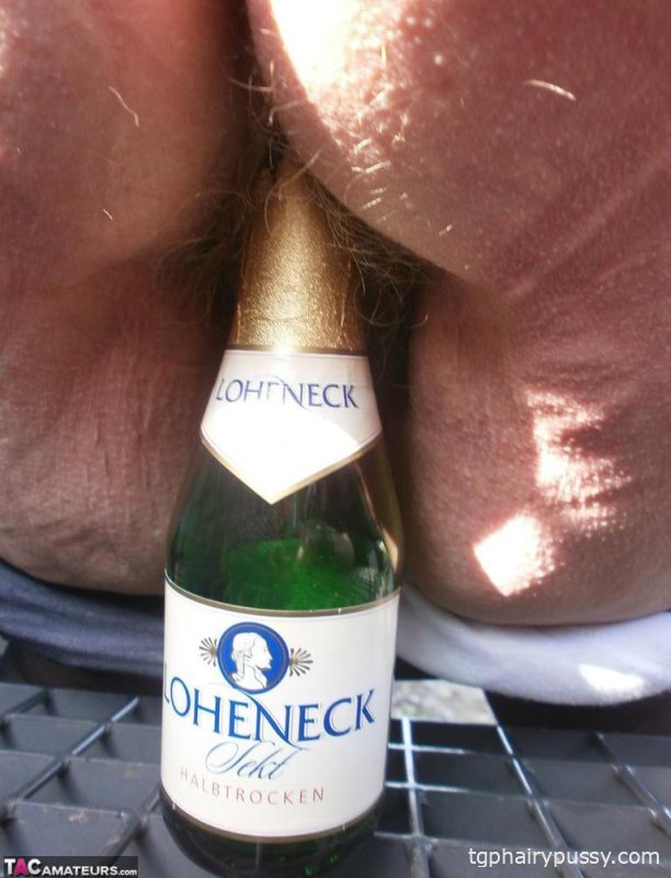 Возбужденная старая Каро на улице в сапогах раздвигает киску, чтобы поиграть с бутылкой вина