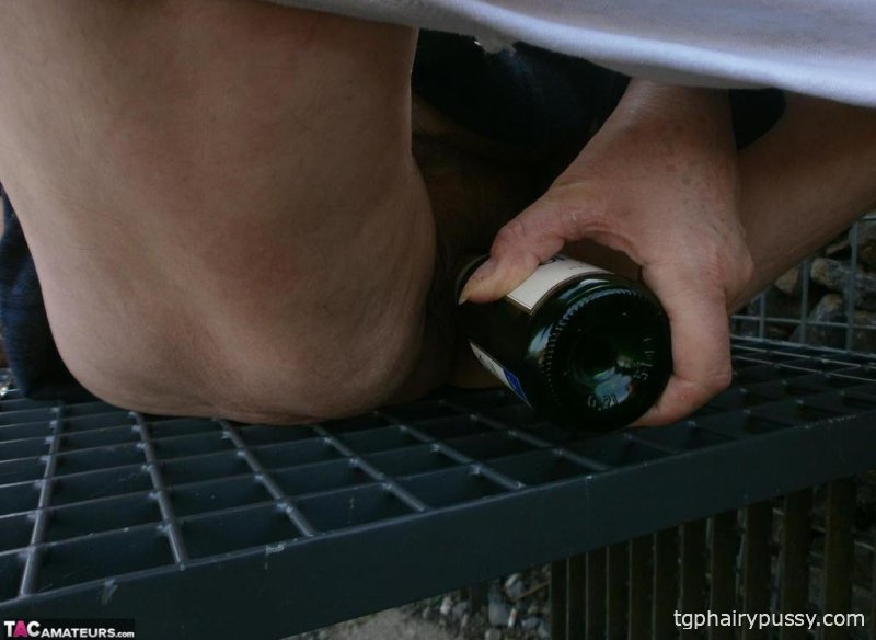 Возбужденная старая Каро на улице в сапогах раздвигает киску, чтобы поиграть с бутылкой вина