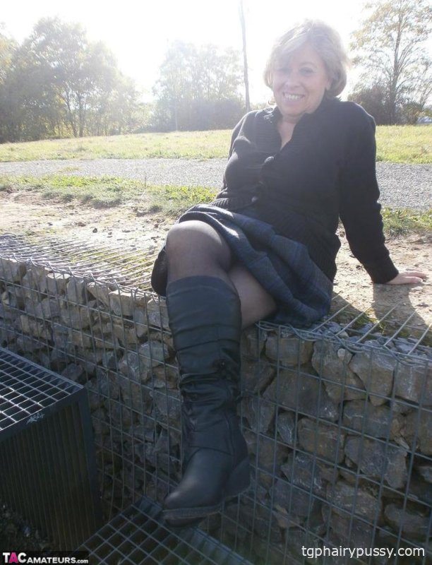 Возбужденная старая Каро на улице в сапогах раздвигает киску, чтобы поиграть с бутылкой вина