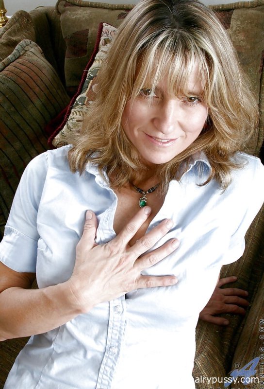 Горячая зрелая дама в мини-юбке показывает свои большие сиськи и мокрую бритую киску.