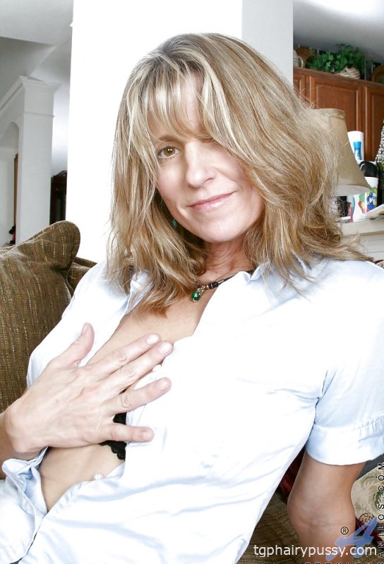 Горячая зрелая дама в мини-юбке показывает свои большие сиськи и мокрую бритую киску.