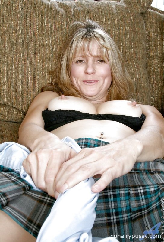 Горячая зрелая дама в мини-юбке показывает свои большие сиськи и мокрую бритую киску.