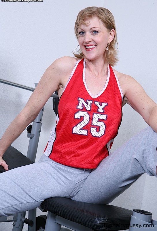 Спортивная зрелая девица раздевается и выставляет напоказ свои товары в спортзале