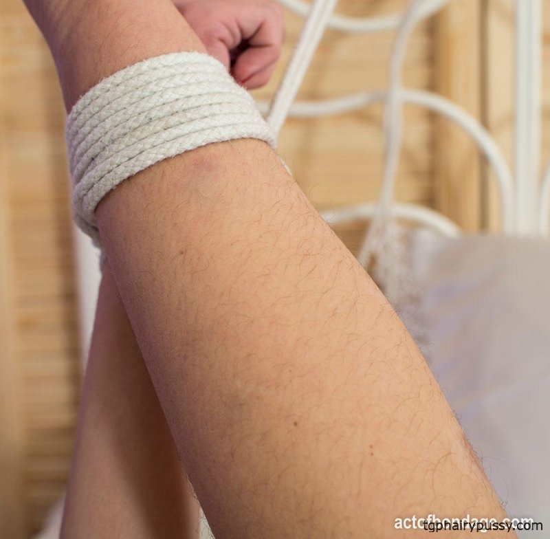 Сексуальная рыжая с волосатыми подмышками связана веревками и с кляпом во рту на кровати